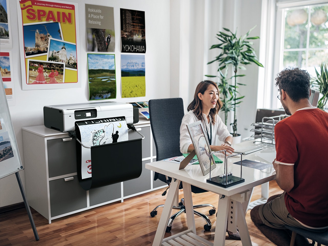 Canon TC-20 M compacte grootformaat printer op een moderne thuiswerkplek met verschillende kantooraccessoires.