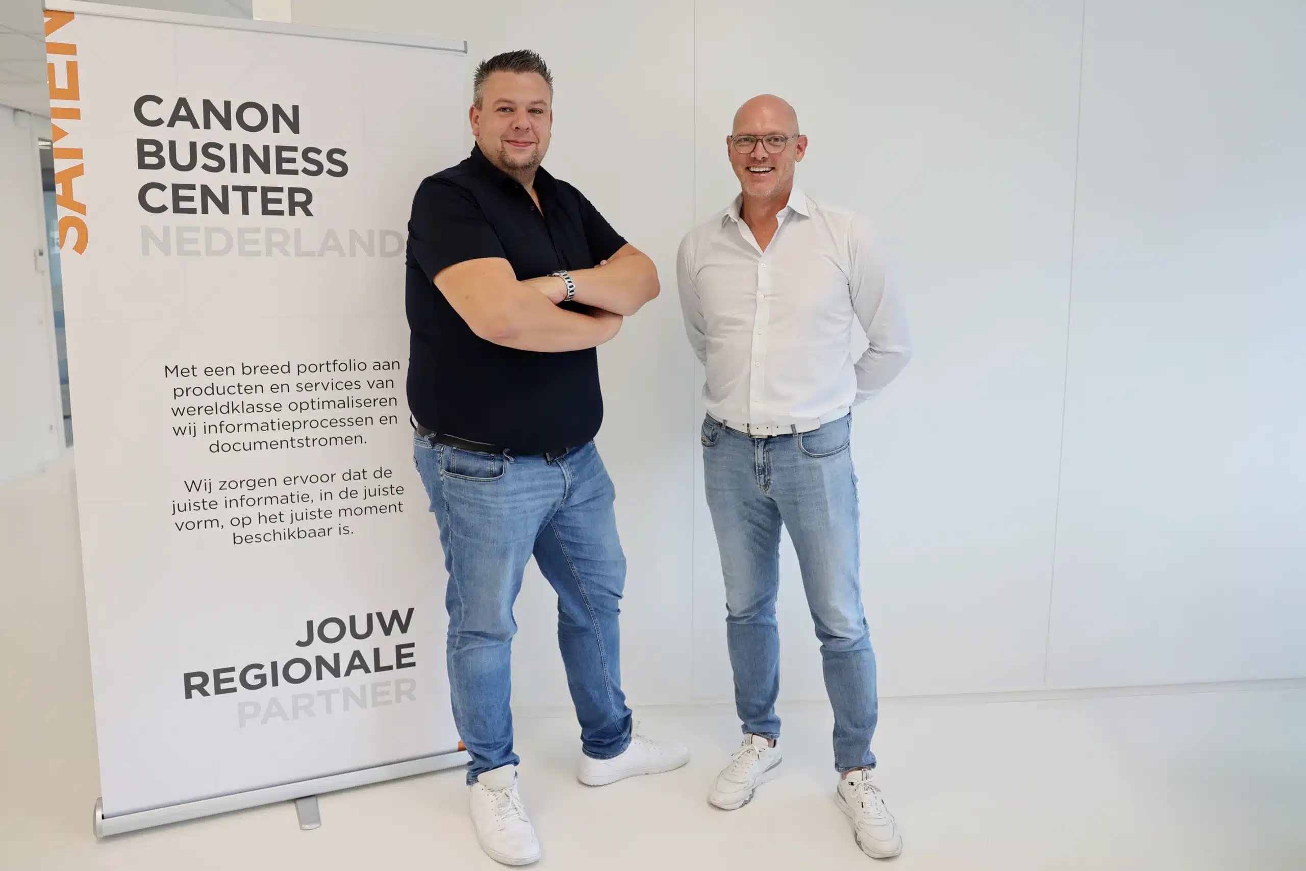 Twee personen bij banner van Canon Business Center Nederland, partner van Mirage ICT-Services
