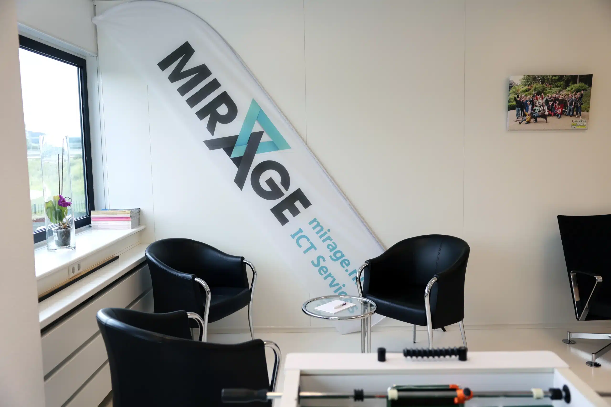 Wachtruimte met banner van Mirage ICT-Services, stoelen en decoratie