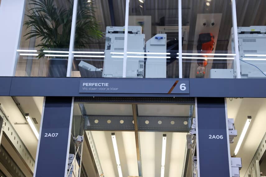 Showroom met printers in het customer center, met het bord “Perfectie – Wij staan voor je klaar