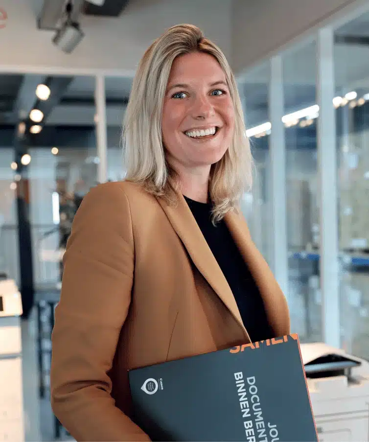 Offerte aanvragen: persoon in bruine blazer met zwarte map in moderne kantooromgeving.