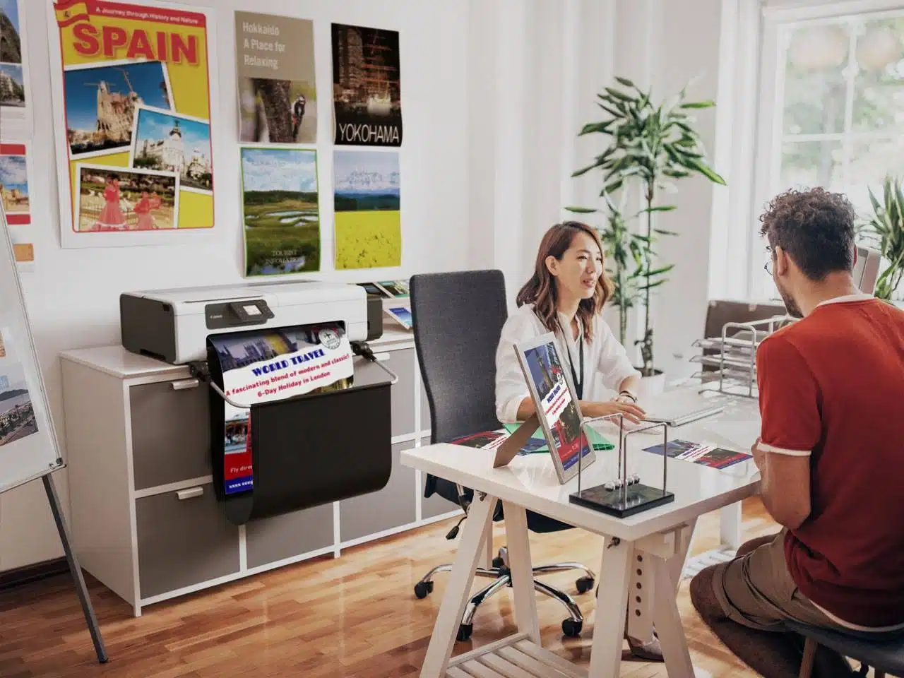 Reisbureau met klantgesprek en een professionele kleurenprinter die een kleurrijke banner print met reisbestemmingen.