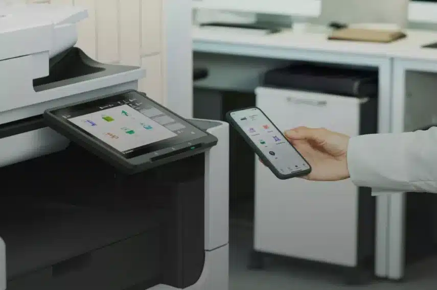 Canon printer verbinden met telefoon via een mobiele app, waarbij een smartphone dicht bij het touchscreen van de printer wordt gehouden.