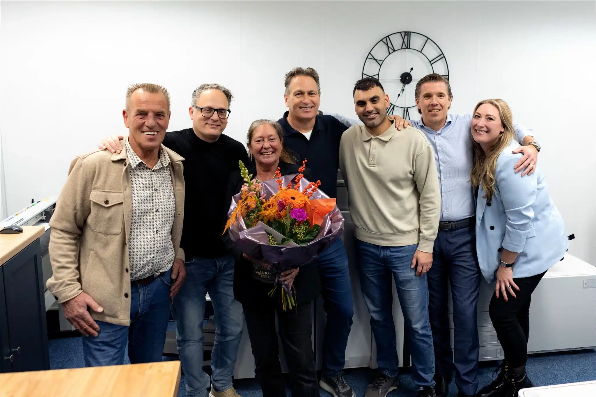 Groepsfoto bij Copyshopdenbosch met een boeket bloemen als teken van waardering.