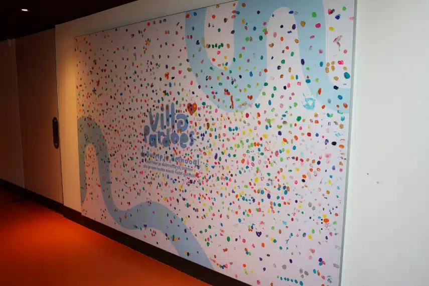 Villa Pardoes muur vol kleurrijke duimpjes en logo in een creatieve en speelse omgeving.