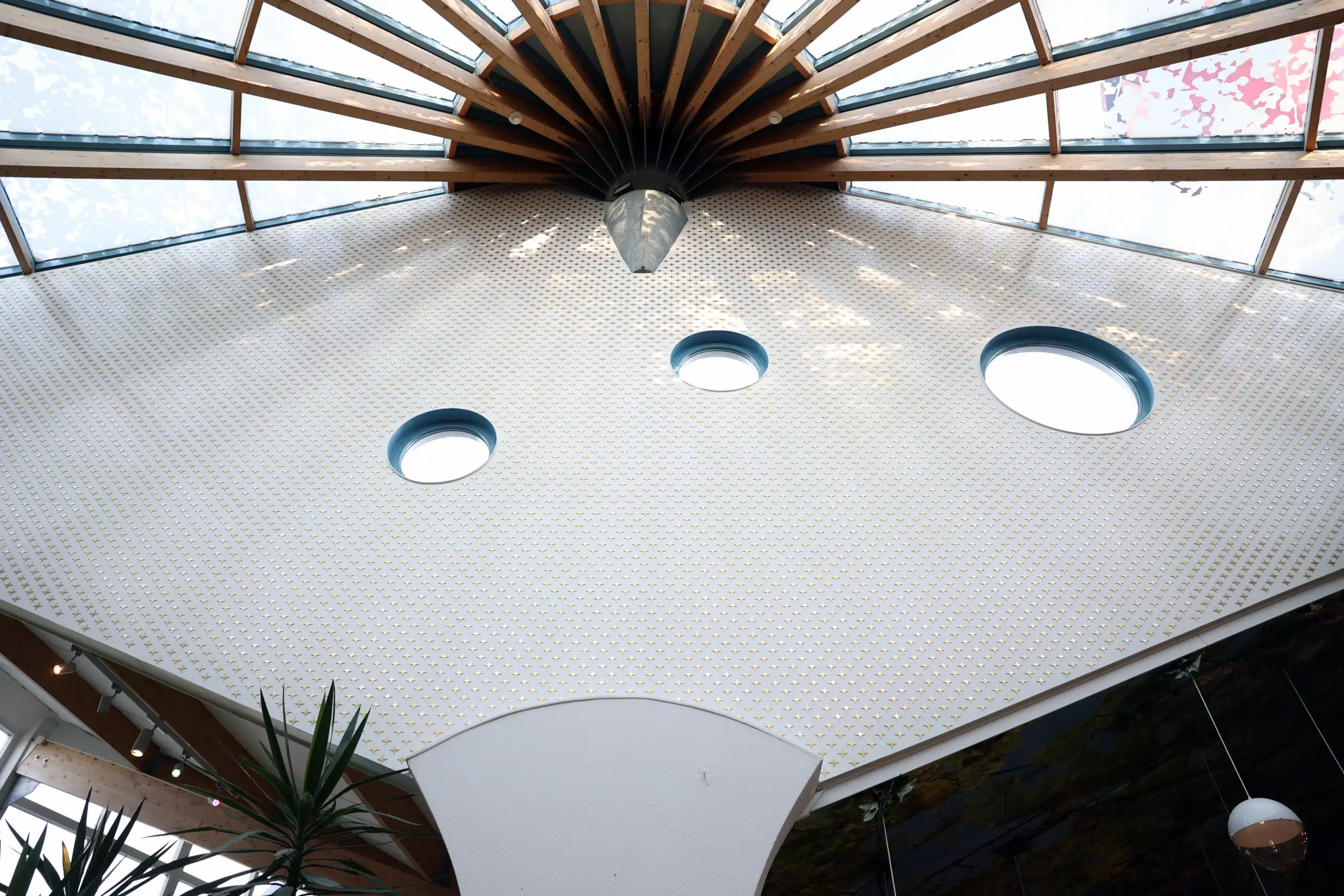 Villa Pardoes plafond met ronde ramen en houten design in een lichte, open ruimte.