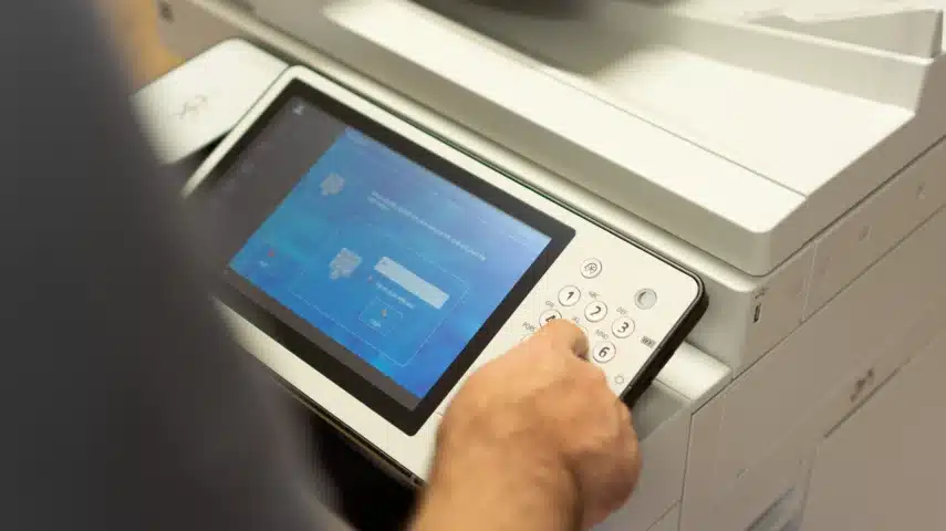 Gebruiker voert toegangscode in op printer voor beveiligde automatisering in print en documentbeheer.