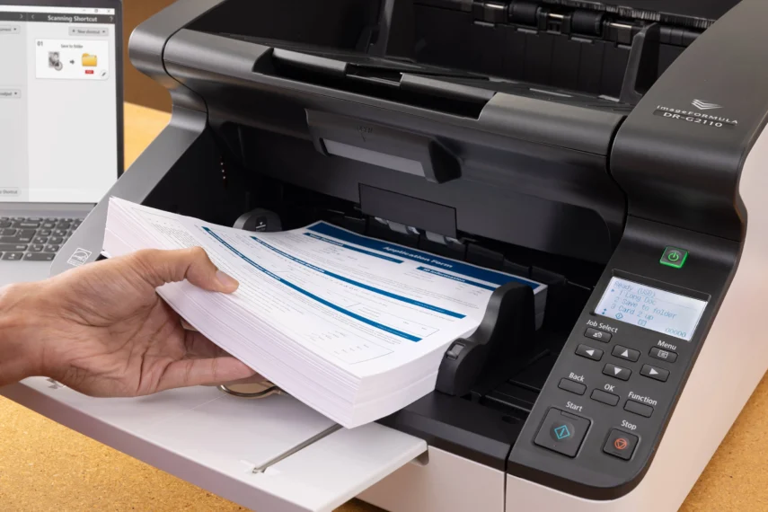 Documentscanner verwerkt een grote stapel formulieren automatisch als onderdeel van automatisering in print en documentworkflows.