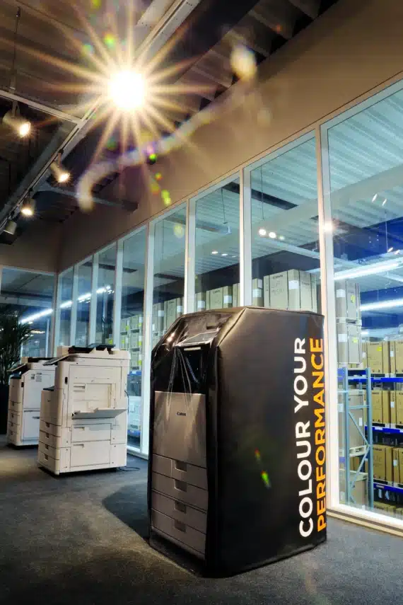 Zakelijke printer in showroom met beschermhoes tijdens het kiezen van een printer voor je bedrijf.