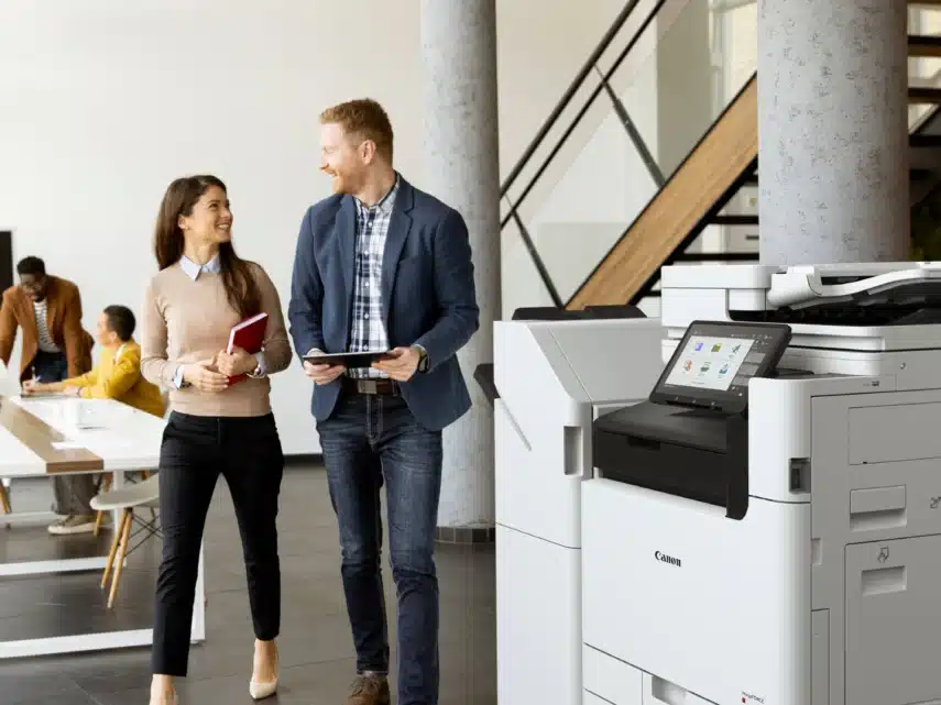 Zakelijke multifunctionele printer in een moderne kantoorruimte met zithoek en werkplekken op de achtergrond.